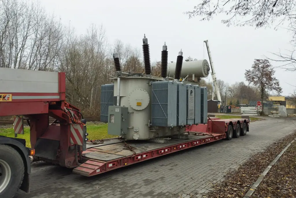 Transport ponadgabarytowy ciężkiego transformatora przemysłowego na specjalistycznej naczepie
